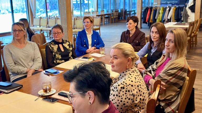 Grupa ludzi siedząca przy stole 1.jpg